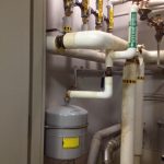 A room featuring various pipes and valves, showcasing an industrial setting with intricate plumbing systems.