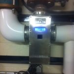 A water meter illuminated by a blue light, showcasing its modern design and functionality in a residential setting.