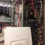 A panel featuring various wires and electrical components, showcasing intricate connections and equipment.