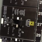 Close-up view of a circuit breaker panel displaying various numbered switches and labels for electrical control.