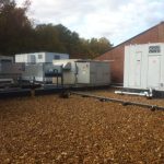 Air conditioning units installed on a gravel-covered rooftop, showcasing a functional urban cooling system.