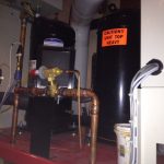 A gas furnace and water heater installed side by side in a utility room, showcasing their functional design and efficiency.
